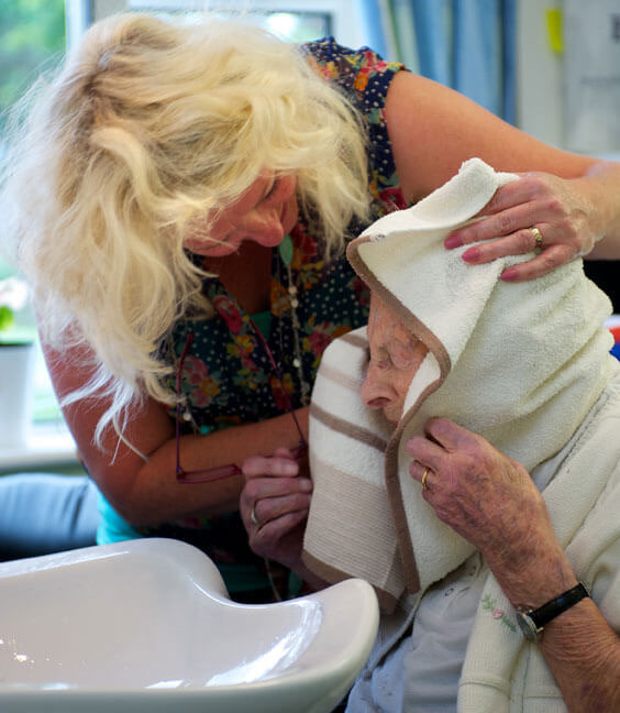 Caremark Domiciliary Care worker washing hair